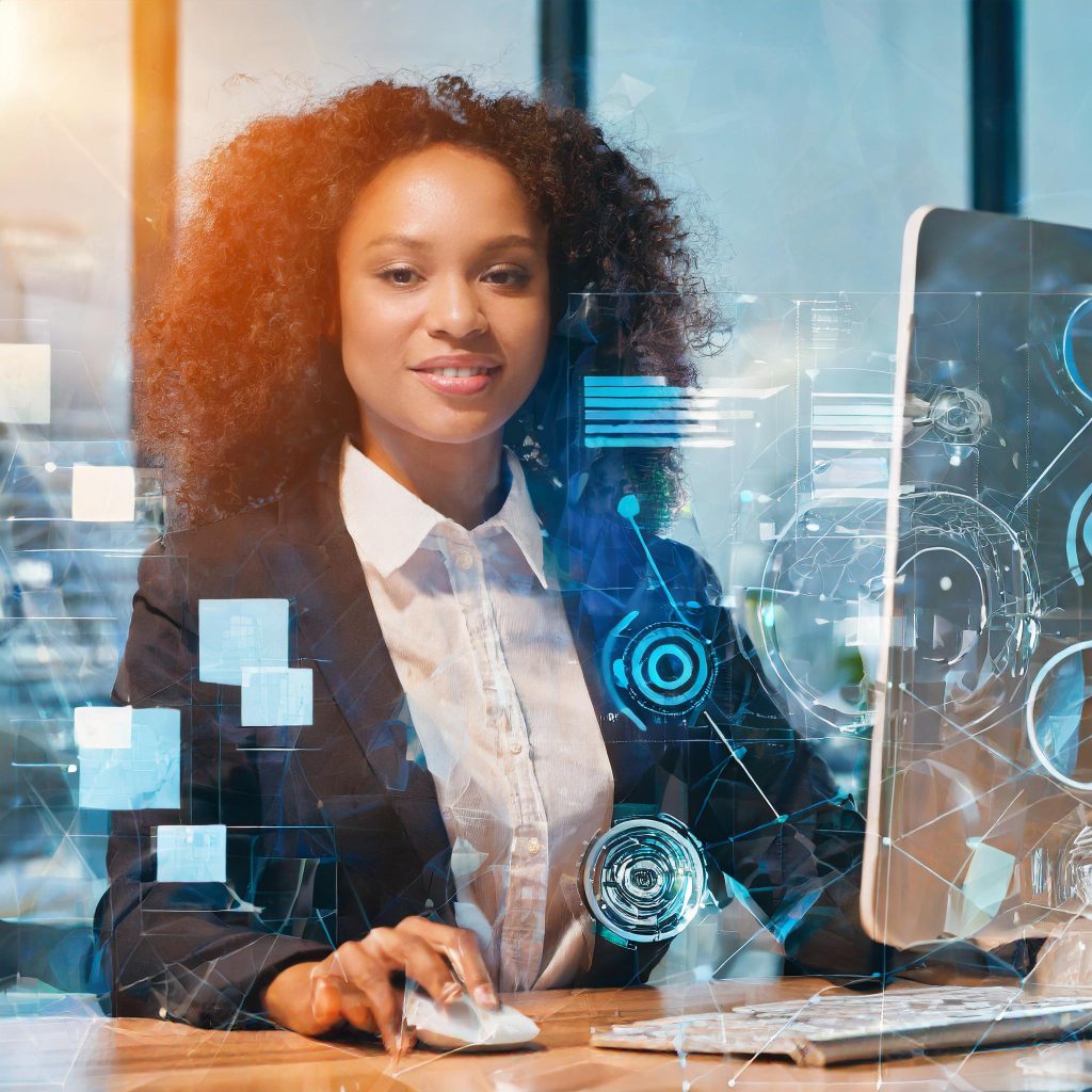Smiling black woman in suit sitting at a desk in front of a computer, representing a pensions administrator.